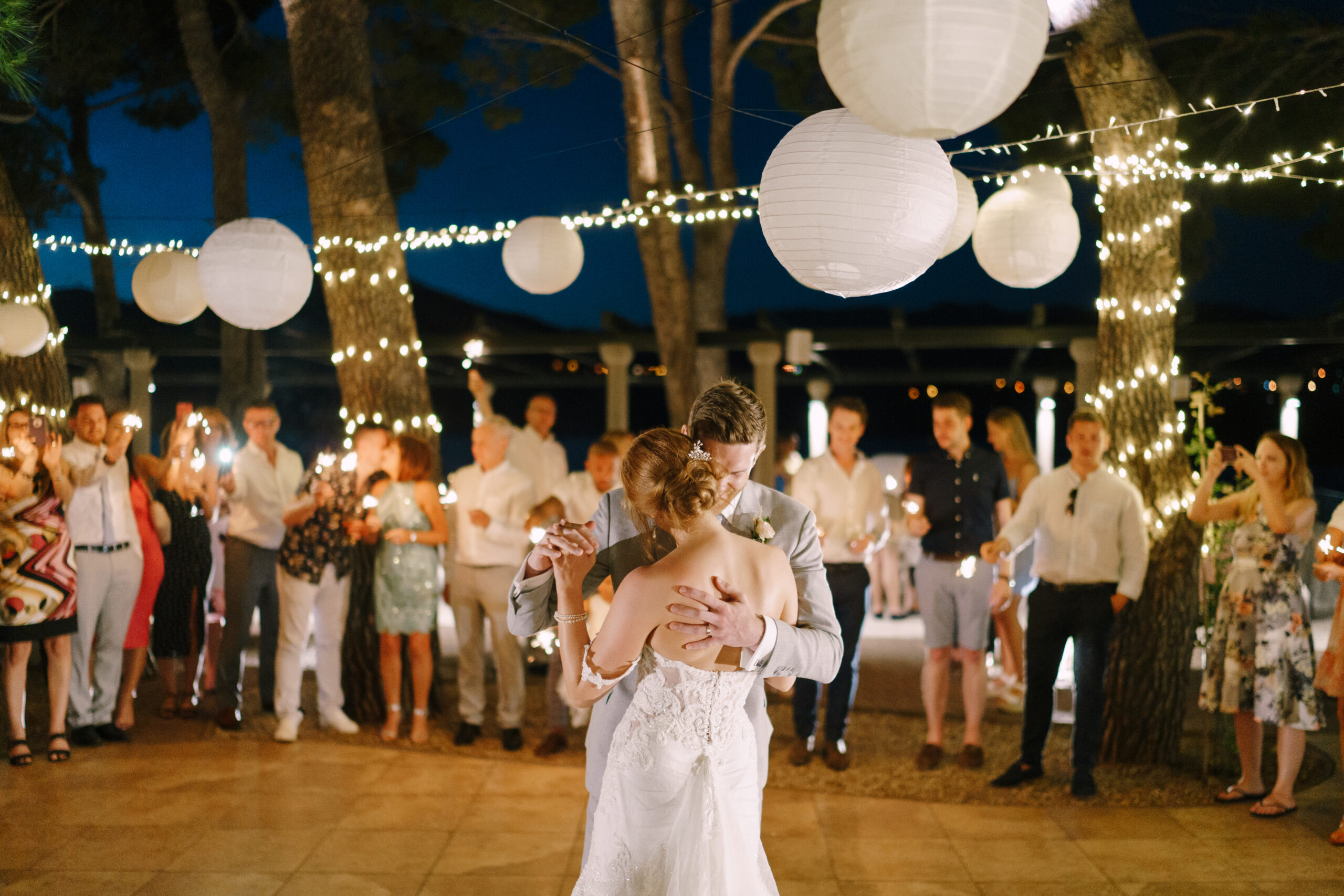 groom is dancing with bride against the background of the guests